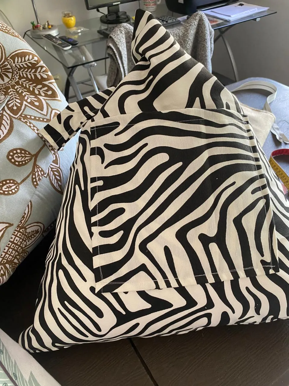 Cojín en forma de pirámide con tela estampada de cebra y un bolsillo